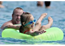 Freibad Mössingen (c) Stadtwerke Mössingen Kind im grünen Schwimmreif im Freibad Mössingen