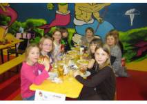 Kinder am Geburtstagstisch im Indoor-Spielplatz