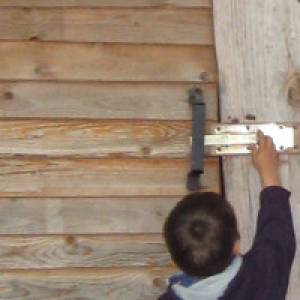 Kind öffnet Holztür