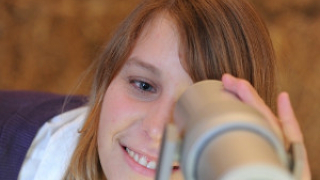 Mädchen schaut durchs Fernrohr